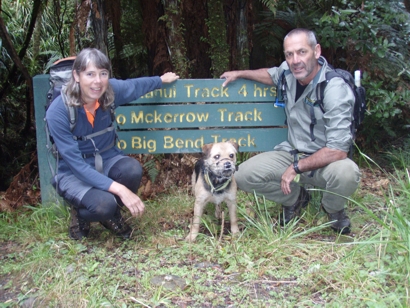 Susan Ellis, kiwi dog "Crete" and dog handler, Scott Theobold pose for a photo at the start of the Whakanui Track