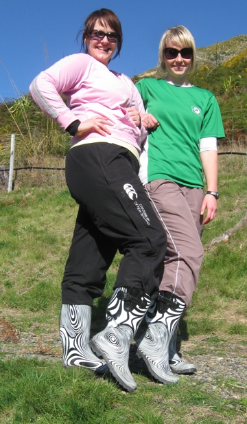 Melissa Middleton & colleague show off their designer gumboots during their community volunteer day's planting efforts. 